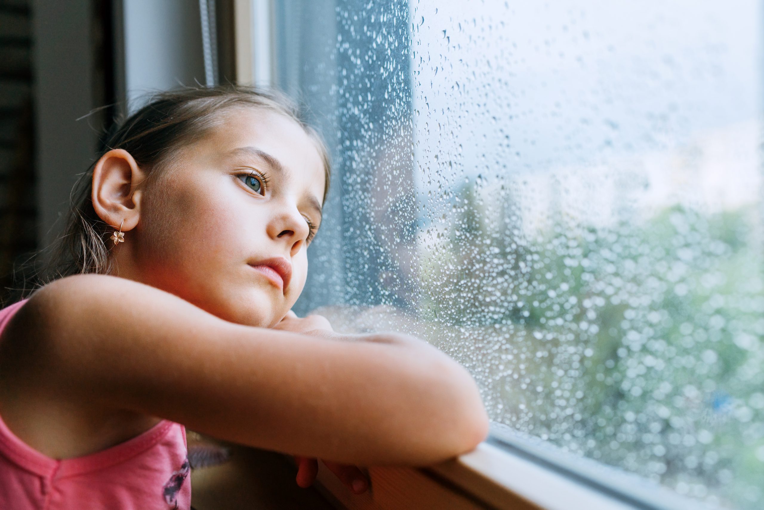 Young girl looking out apartment window